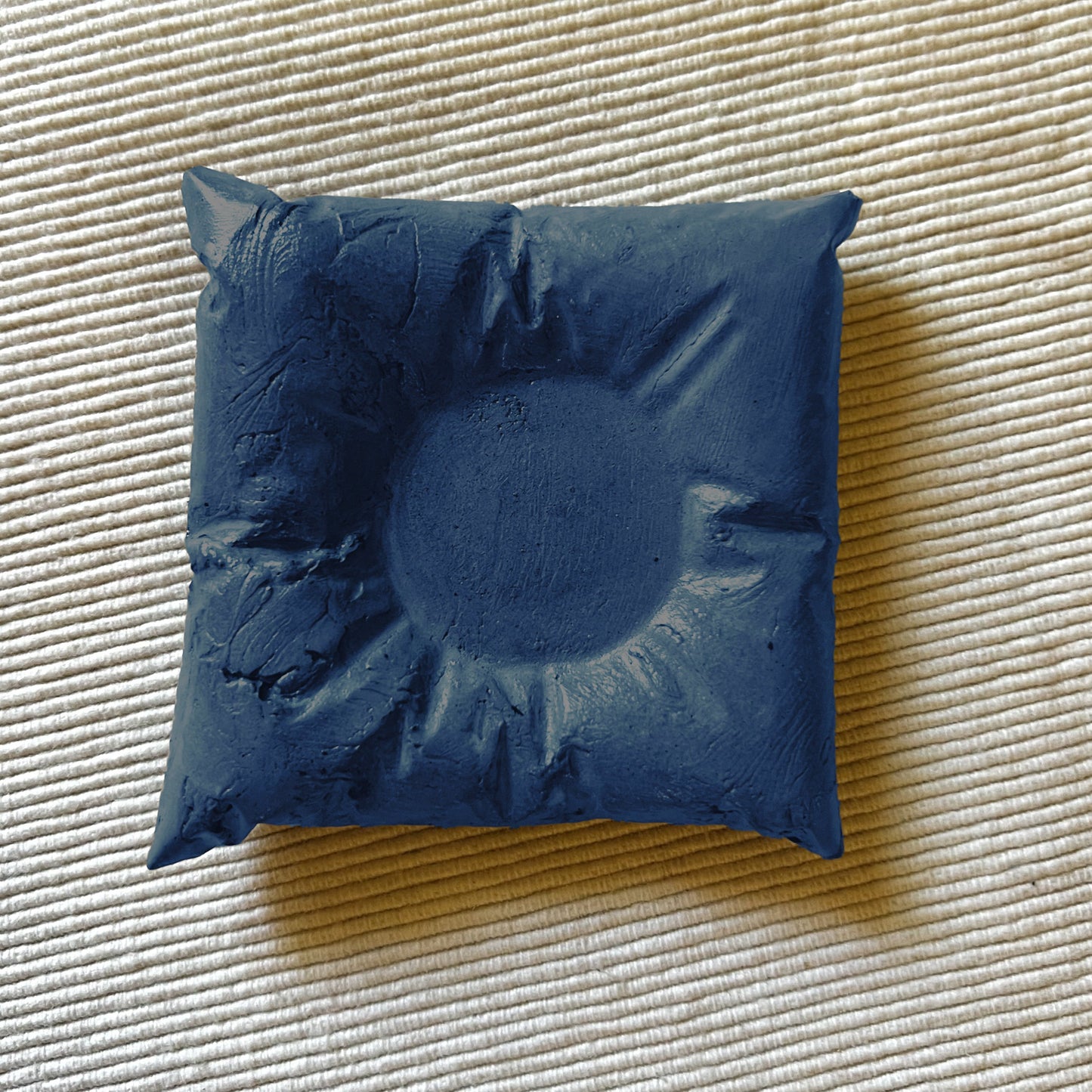 Ukrasni jastucic napravljen rucno od betonske smjese svijetlo plave boje