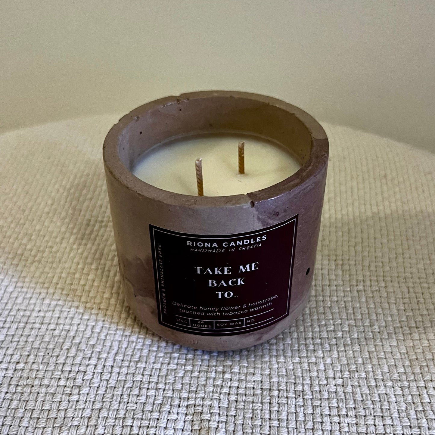 Velika svijeca rucno izradena od prirodnog sojinog voska u betonskoj posudici s notama meda i slatkog badema